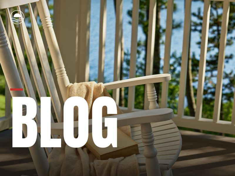 BLOG: a white porch rocker with a book, the lake beyond