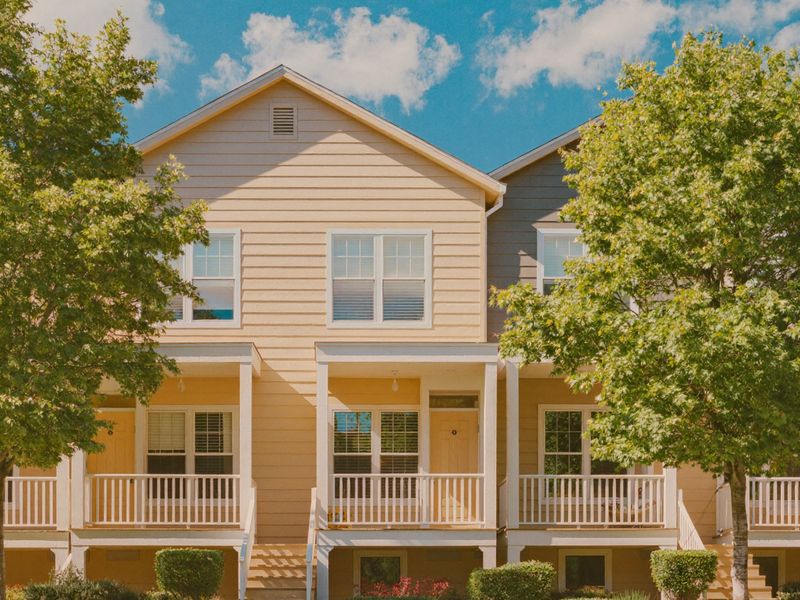 A row of sunny two-story rental homes with porches