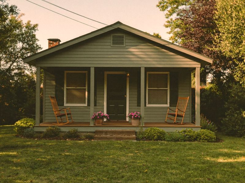 A small porch house with rocking chairs on a summer evening